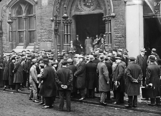 Unemployed men queue outside a former workhouse, 1930.  Source:  Bundesarchiv, Bild 102-10246 / CC-BY-SA 3.0